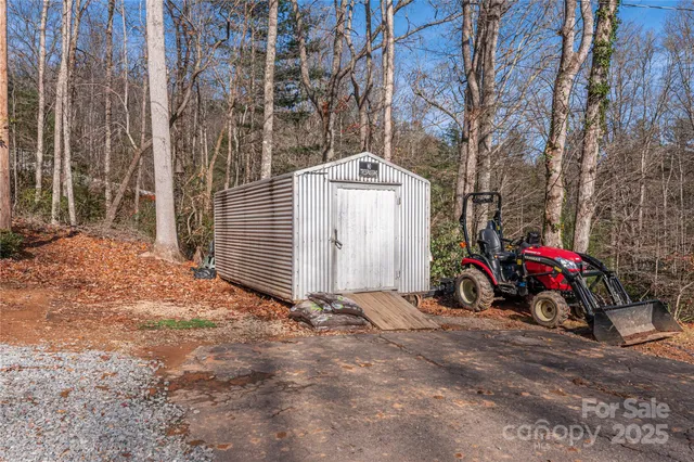 a view of a garage with a car parked beside of it