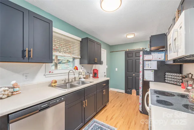 a kitchen that has a lot of cabinets a sink and appliances in it