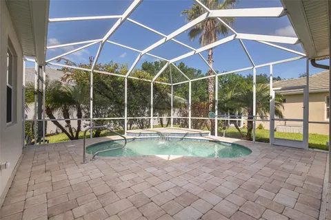 a view of a backyard with swimming pool and sitting area