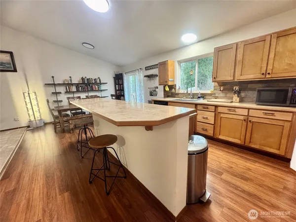 a kitchen with stainless steel appliances a table chairs refrigerator and cabinets