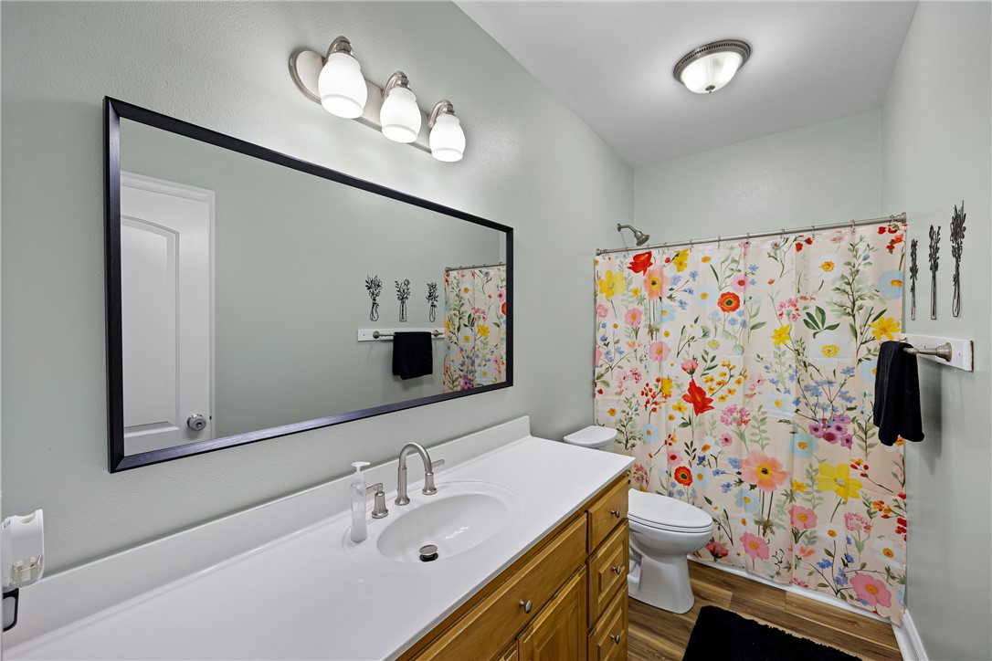 751 Walthall Road Russellville, AR 72802 - Photo 22 of 60 Bathroom featuring a single vanity with a white countertop, wood-finish cabinetry, a large framed mirror, and a shower-tub combination