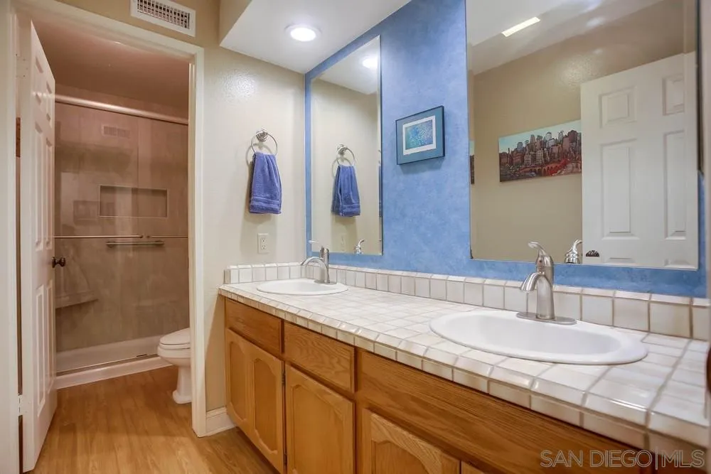 13036 Treecrest Street Poway, CA 92064 - Photo 20 of 37 a bathroom with a granite countertop sink a mirror a shower and a bathtub