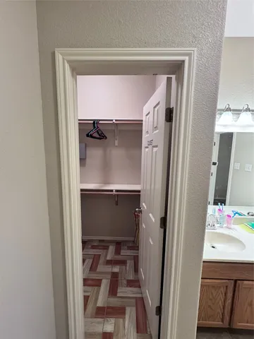 a bathroom with a walk in closet and wooden floor