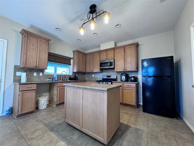 a kitchen with kitchen island granite countertop cabinets and refrigerator