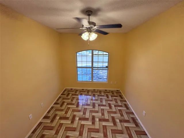 a view of a hallway with wooden floor and a window
