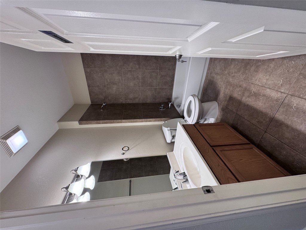 11202 Granados Street Laredo, TX 78045 - Photo 6 of 17 a bathroom with a sink a toilet and a mirror