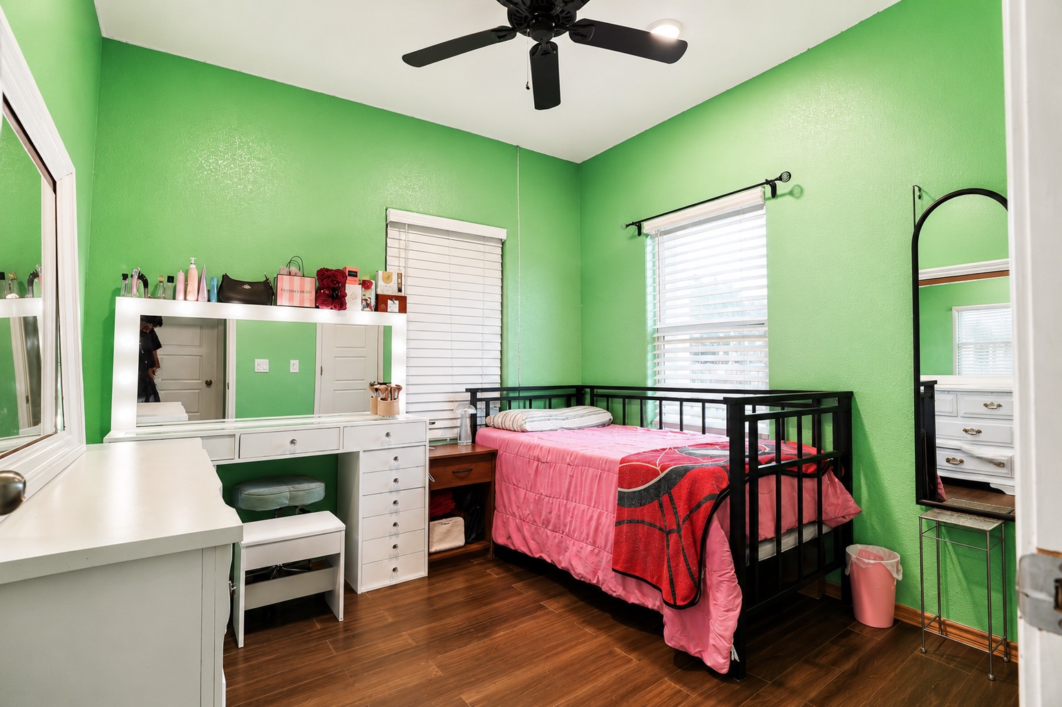 130 Los Arcos Road Elgin, TX 78621 - Photo 33 of 39 A cozy bedroom features rich wood flooring, a convenient ceiling fan, and ample natural light from the well-placed window.