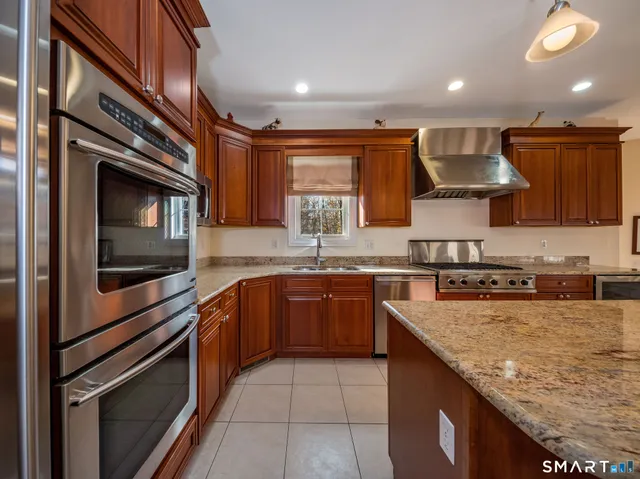 a kitchen with stainless steel appliances granite countertop a sink stove and microwave