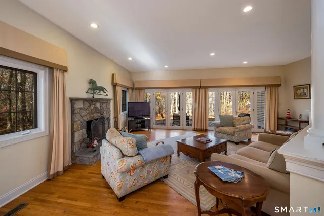 a living room with fireplace furniture and a large window