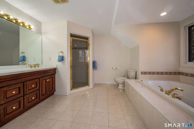 a spacious bathroom with a tub sink double vanity and mirror