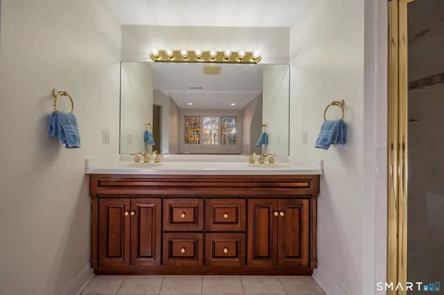 a spacious bathroom with a granite countertop sink and a mirror