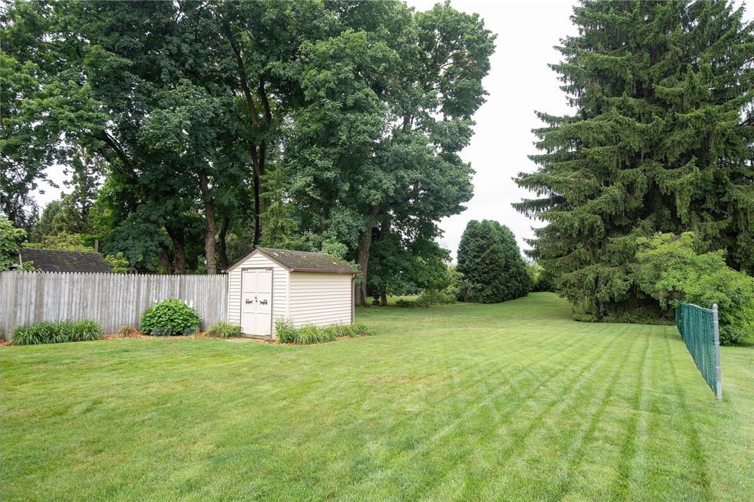706 Stones Crossing Road Easton, PA 18045 - Photo 32 of 40 A verdant backyard with mature trees, a privacy fence, and a quaint storage shed.