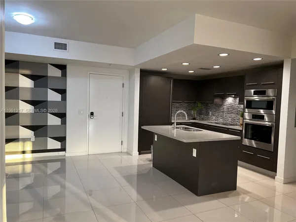 a kitchen with stainless steel appliances granite countertop a sink and a refrigerator
