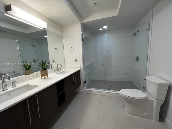 a bathroom with a double vanity sink toilet and shower