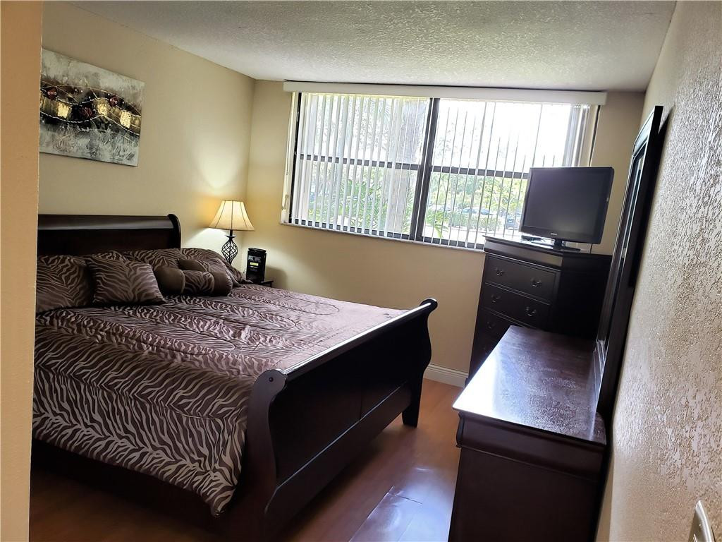 16325 Golf Club Road, Unit 112 Weston, FL 33326 - Photo 12 of 26 a bedroom with a bed window and a desk