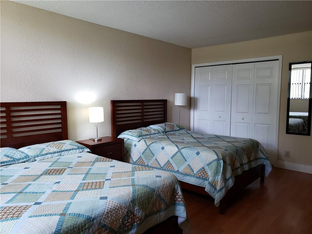 16325 Golf Club Road, Unit 112 Weston, FL 33326 - Photo 16 of 26 a bedroom with a bed and wooden floor