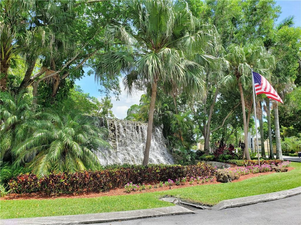 16325 Golf Club Road, Unit 112 Weston, FL 33326 - Photo 2 of 26 a flag is sitting in the middle of a yard
