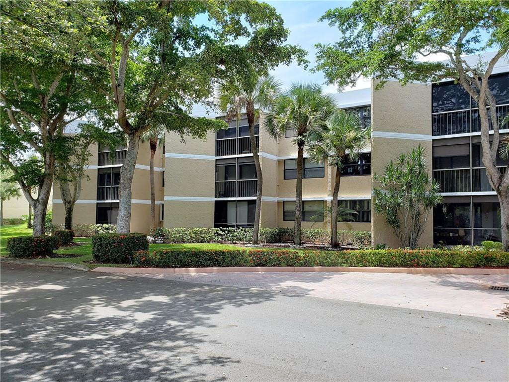 16325 Golf Club Road, Unit 112 Weston, FL 33326 - Photo 25 of 26 a front view of a house with a garden