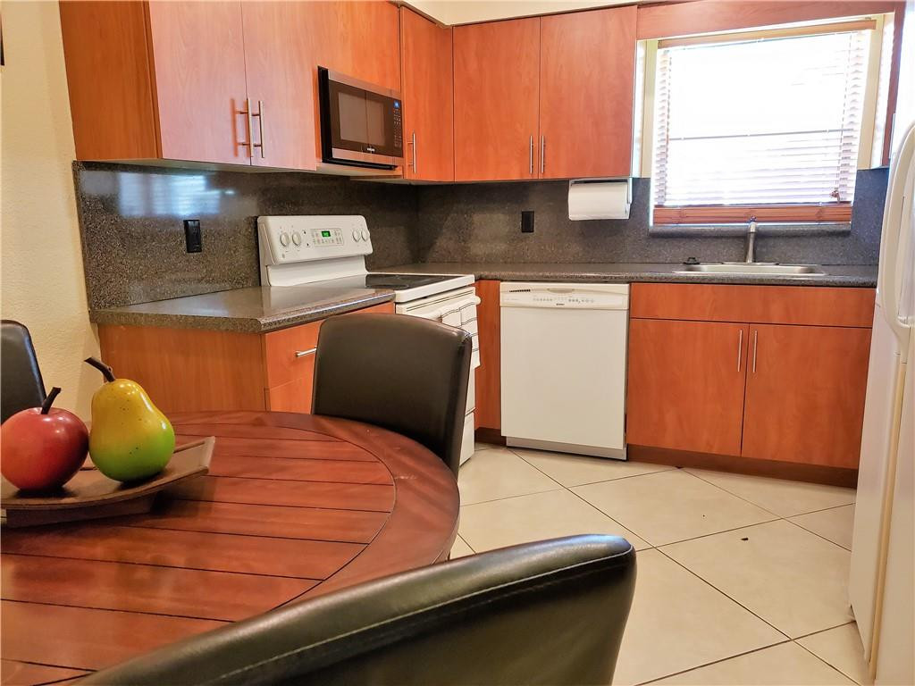 16325 Golf Club Road, Unit 112 Weston, FL 33326 - Photo 6 of 26 a kitchen with stainless steel appliances kitchen island granite countertop a sink a stove and cabinets