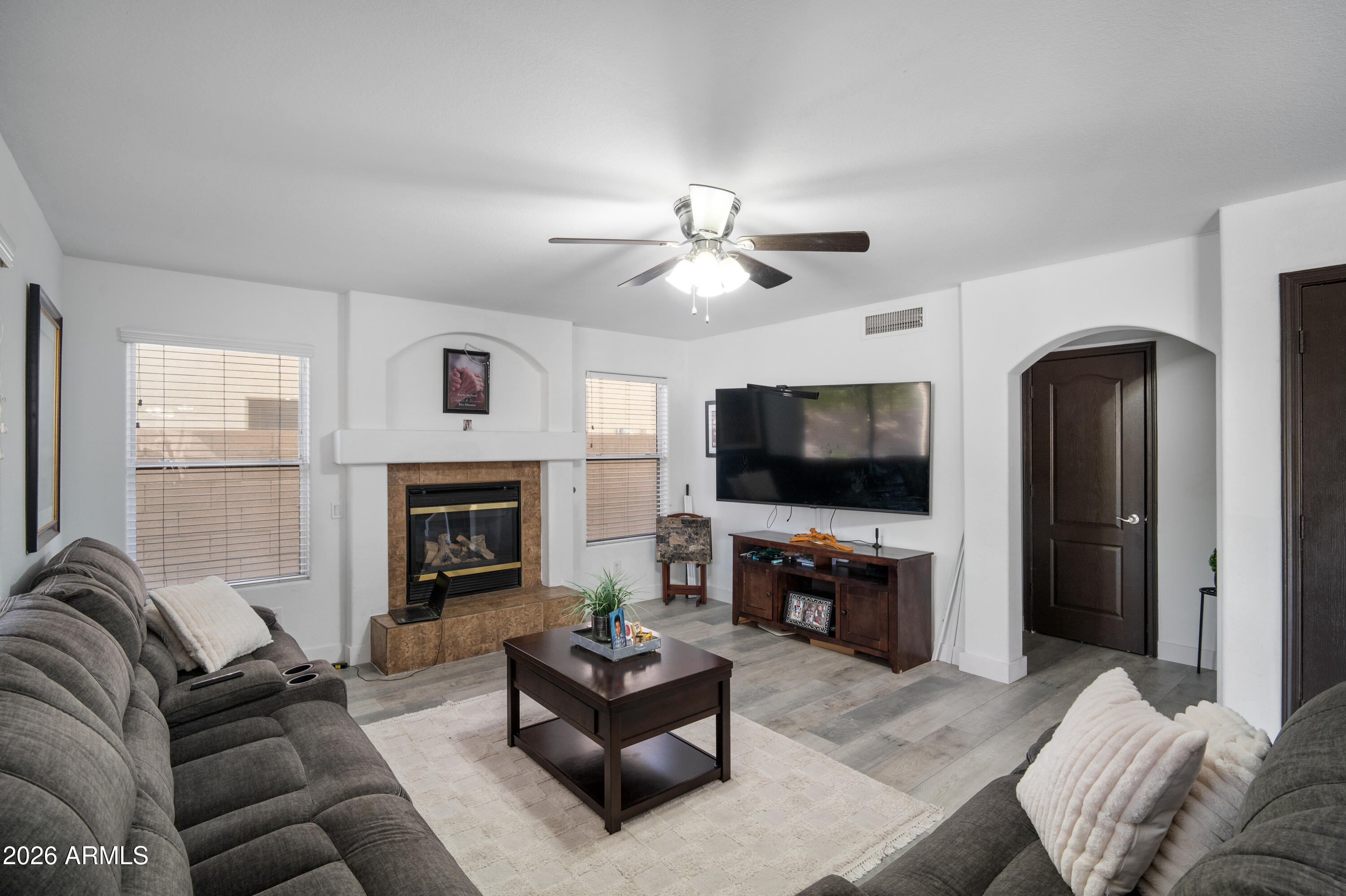 16221 West Latham Street Goodyear, AZ 85338 - Photo 11 of 30 a living room with furniture a fireplace and a flat screen tv