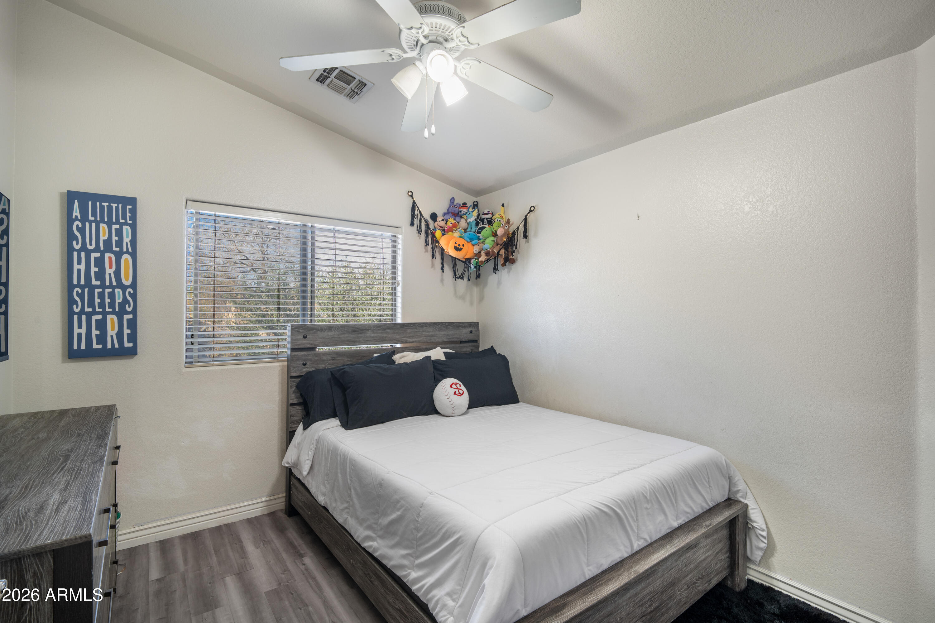 16221 West Latham Street Goodyear, AZ 85338 - Photo 17 of 30 a bedroom with a bed and a window