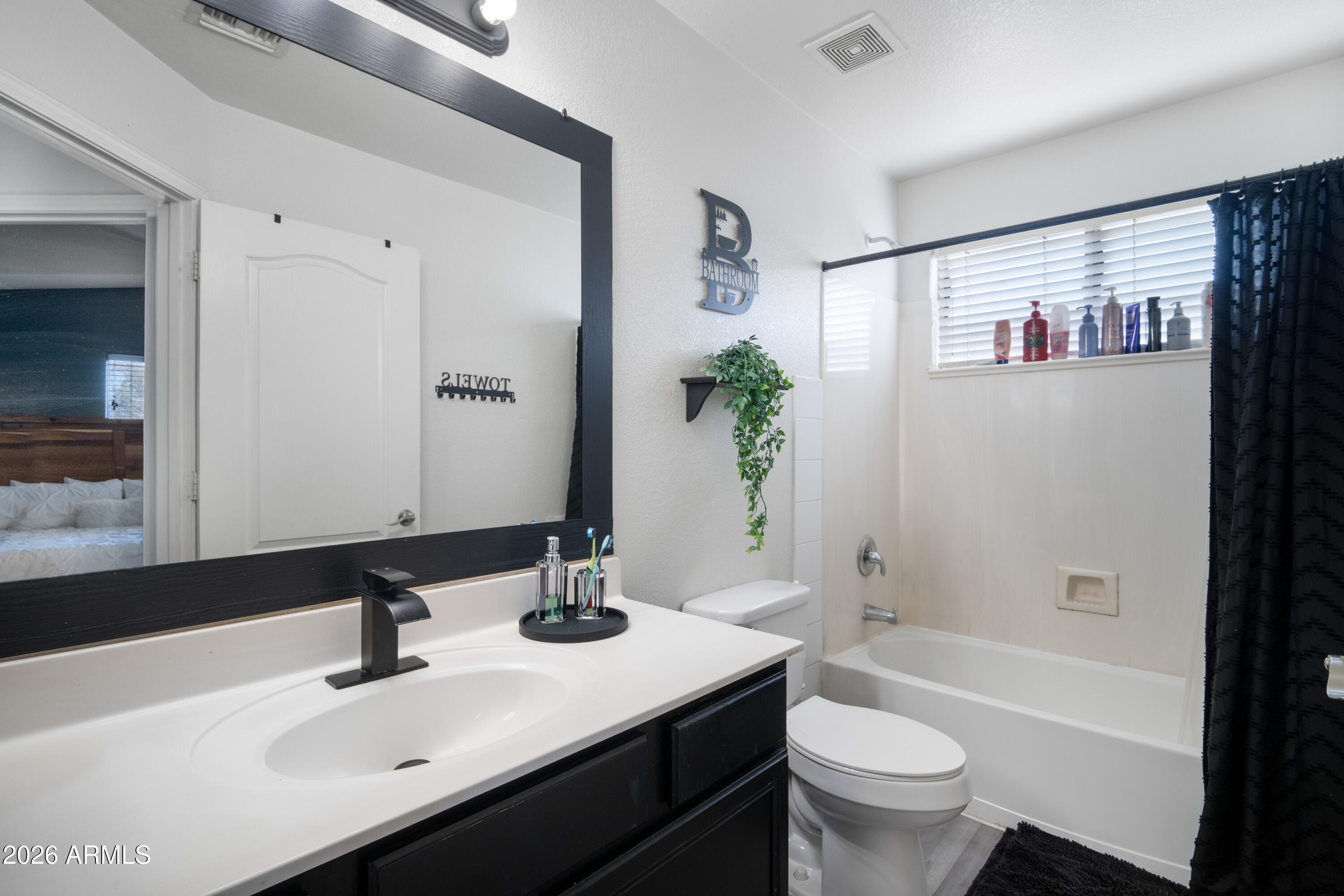 16221 West Latham Street Goodyear, AZ 85338 - Photo 19 of 30 a bathroom with a sink a toilet a tub and shower