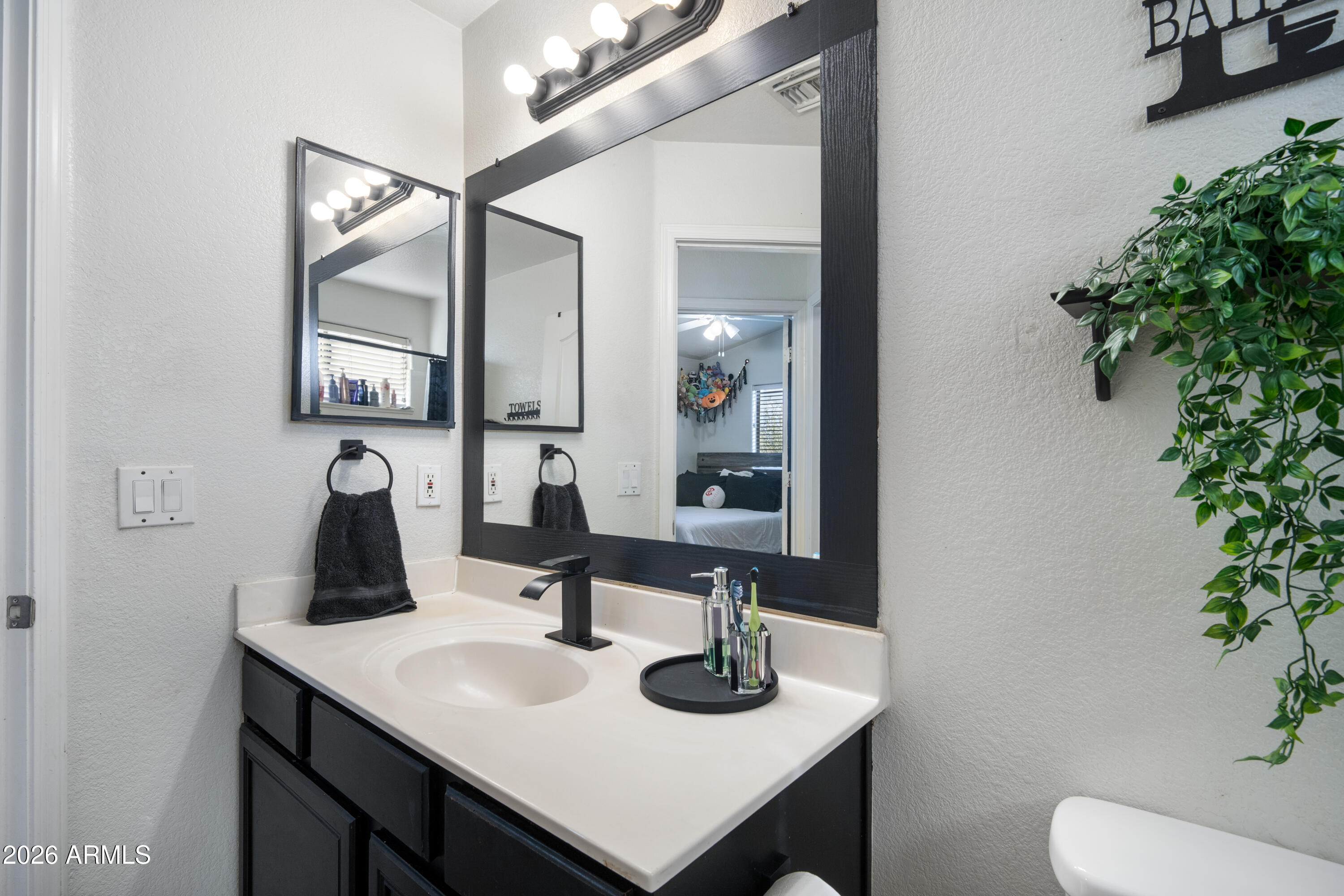 16221 West Latham Street Goodyear, AZ 85338 - Photo 20 of 30 a bathroom with a toilet sink and mirror