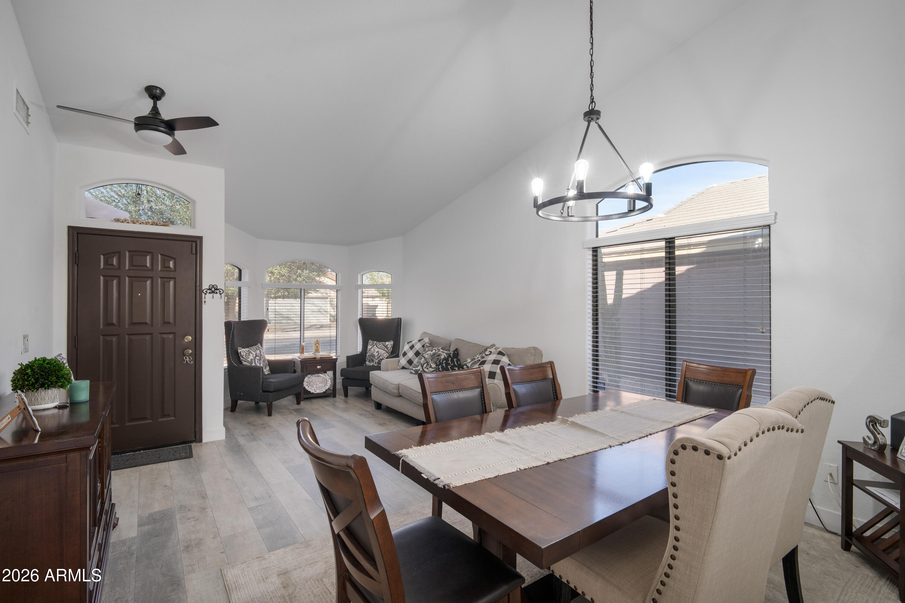 16221 West Latham Street Goodyear, AZ 85338 - Photo 5 of 30 a view of a dining room with furniture a chandelier and wooden floor