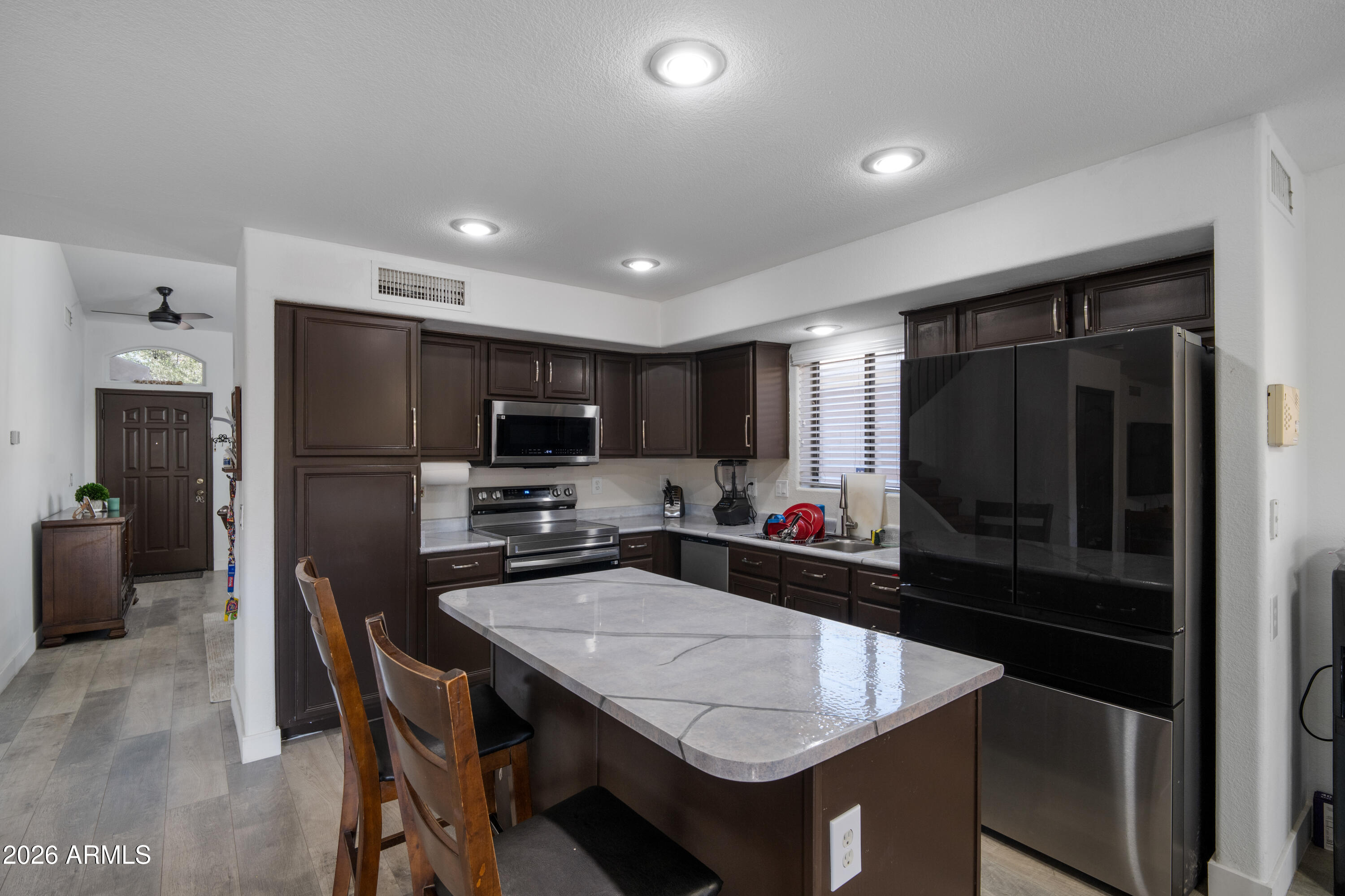 16221 West Latham Street Goodyear, AZ 85338 - Photo 9 of 30 a kitchen with a table and refrigerator in it