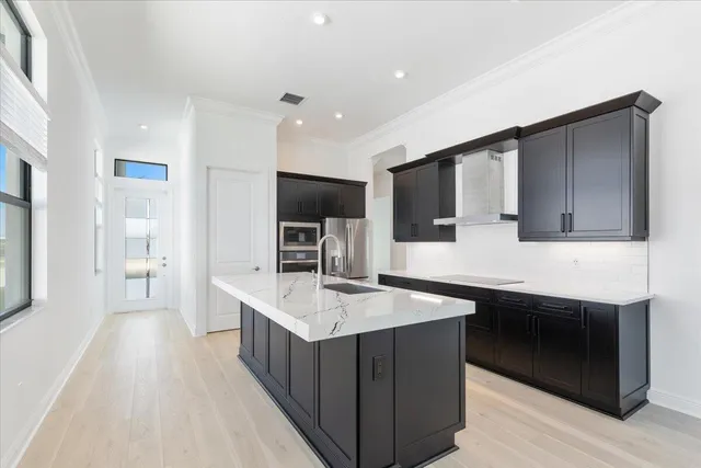 a kitchen with stainless steel appliances kitchen island granite countertop a sink stove and refrigerator
