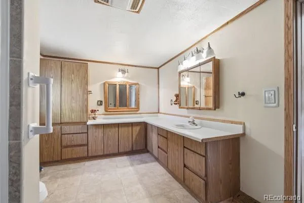 a spacious bathroom with a granite countertop sink and a mirror