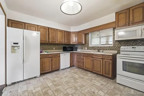 a kitchen with granite countertop a refrigerator sink and cabinets