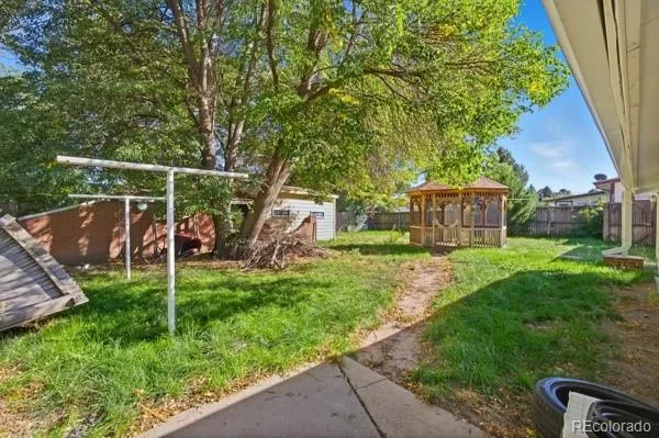 a view of a house with backyard and a tree