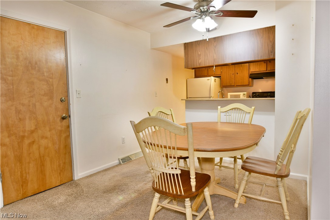 2980 North River Road Northeast, Unit E3 Warren, OH 44483 - Photo 9 of 27 Dining space featuring ceiling fan and light colored carpet