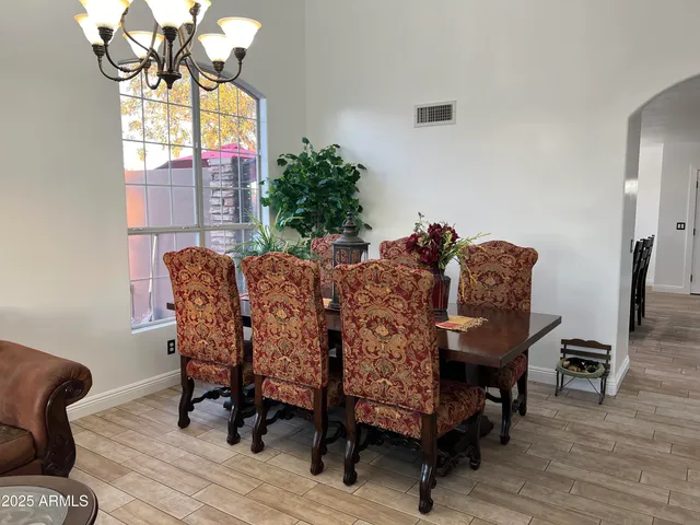 a kitchen with a dining table chairs and refrigerator