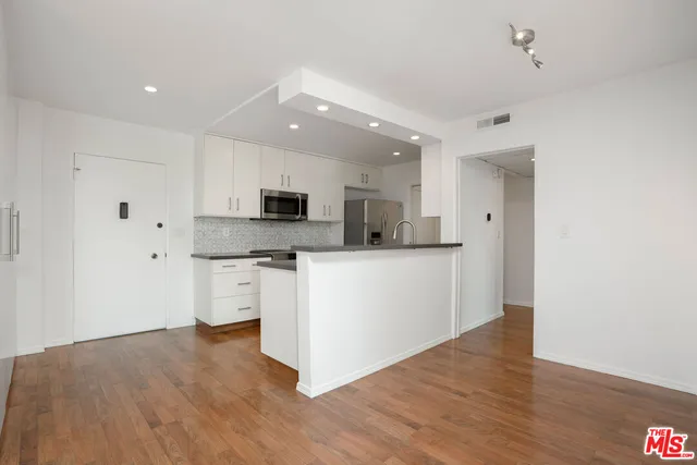 a kitchen with stainless steel appliances a refrigerator sink and microwave