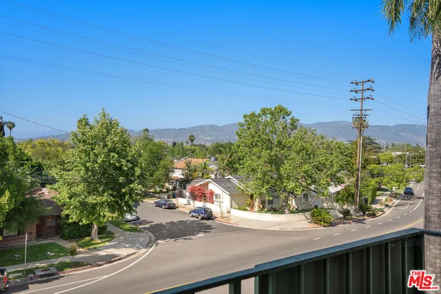 a living room with furniture a flat screen tv and kitchen view