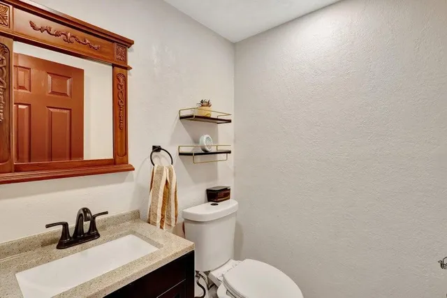 a bathroom with a toilet a sink and mirror