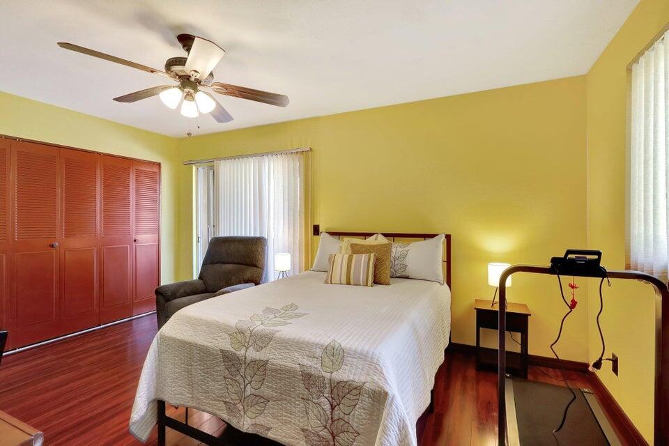 278 Monaco Way, Unit F Delray Beach, FL 33446 - Photo 13 of 19 a bedroom with a bed and wooden floor