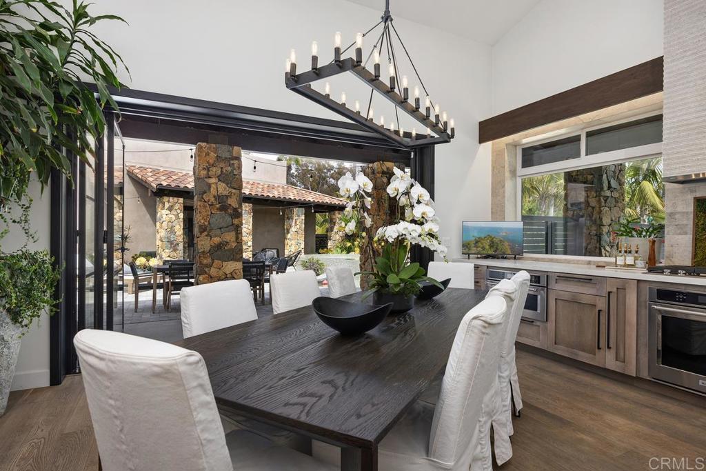 1240 Berryman Canyon Encinitas, CA 92024 - Photo 14 of 64 a dining room with furniture a chandelier and wooden floor