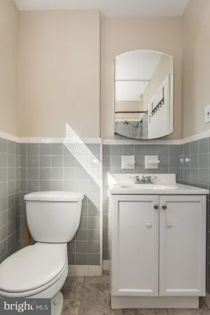 a bathroom with a toilet a sink and mirror