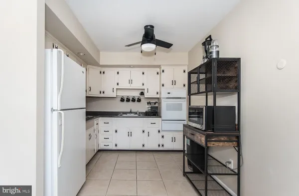 a kitchen with granite countertop a refrigerator a stove a microwave and cabinets
