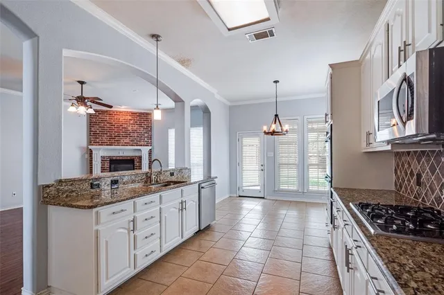 a kitchen with stainless steel appliances granite countertop a stove a sink and a refrigerator