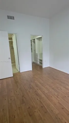 an empty room with wooden floor and mirror