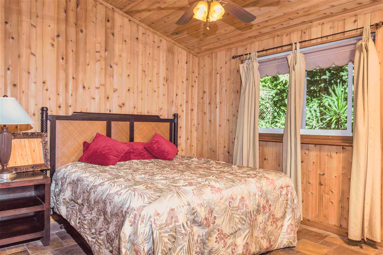 900 Haiku Road Haiku, HI 96708 - Photo 12 of 15 a bedroom with a bed and wooden floor