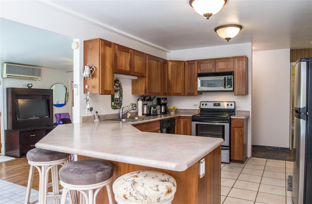 900 Haiku Road Haiku, HI 96708 - Photo 5 of 15 a kitchen with stainless steel appliances a stove a sink and a refrigerator