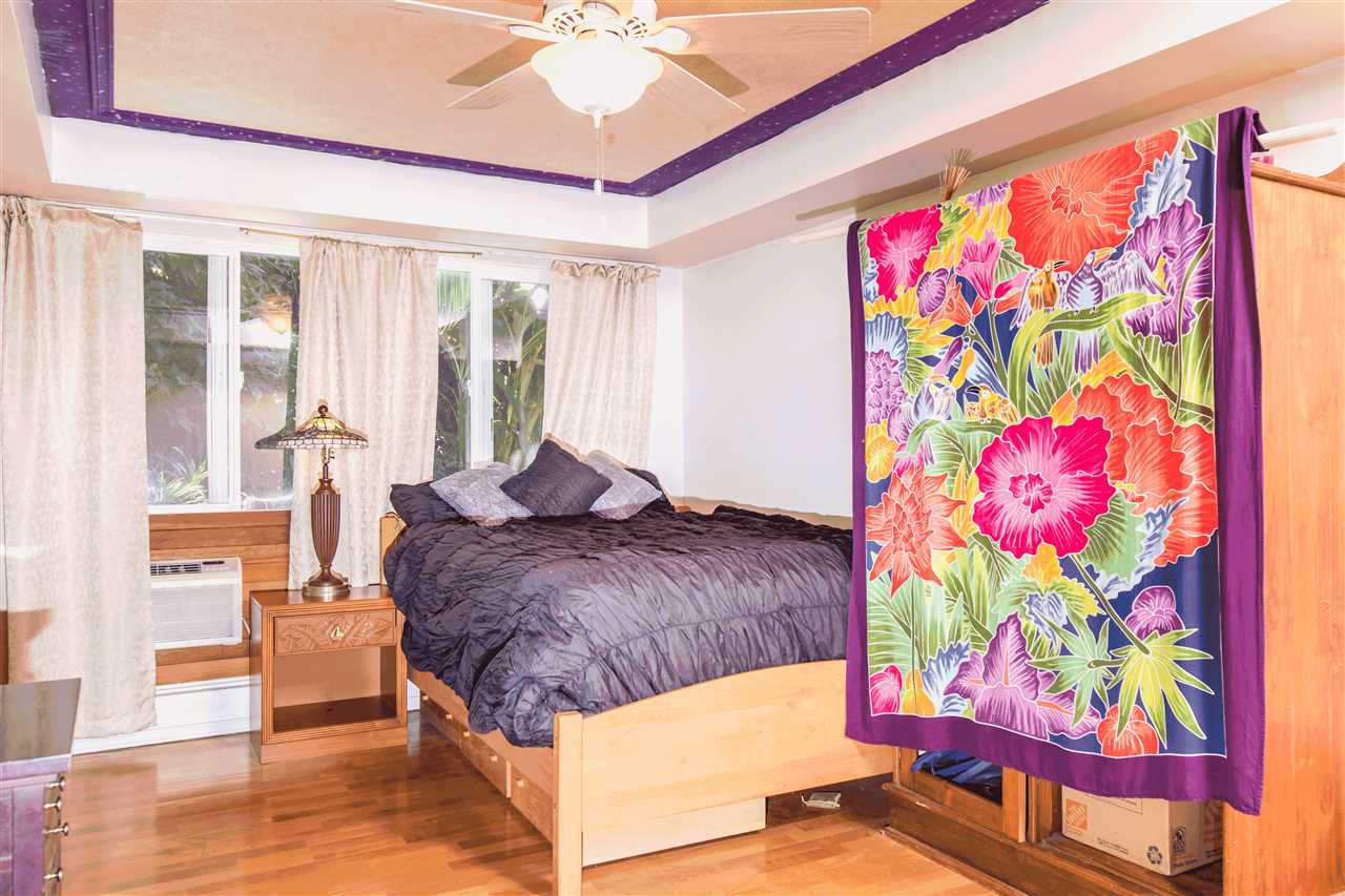 900 Haiku Road Haiku, HI 96708 - Photo 8 of 15 a bedroom with a bed and a painting on the wall