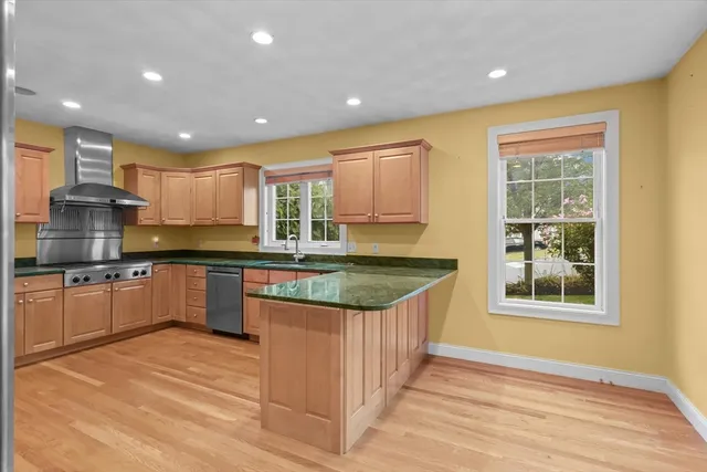 a kitchen with stainless steel appliances granite countertop a stove a sink and a refrigerator