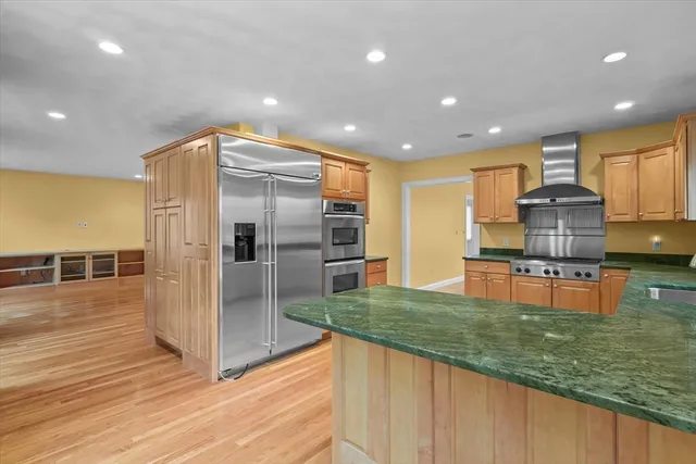 a kitchen with stainless steel appliances granite countertop a refrigerator and a stove