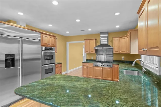 a kitchen with stainless steel appliances granite countertop a sink stove and refrigerator